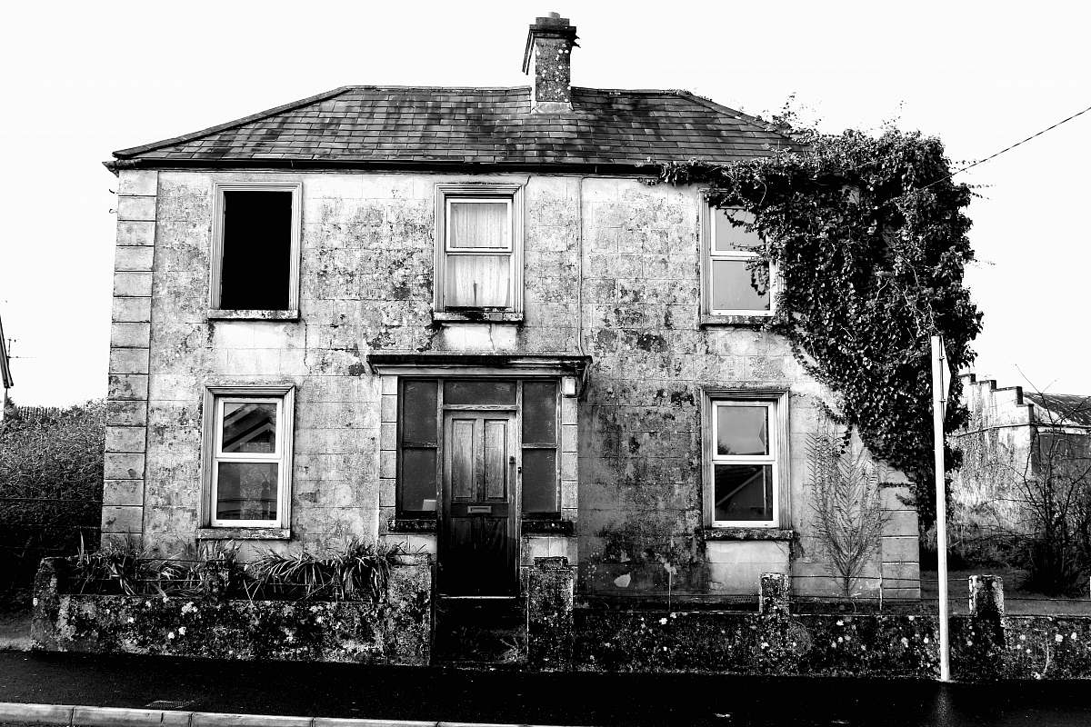 outdoors greyscale photo of white concrete house during daytime house