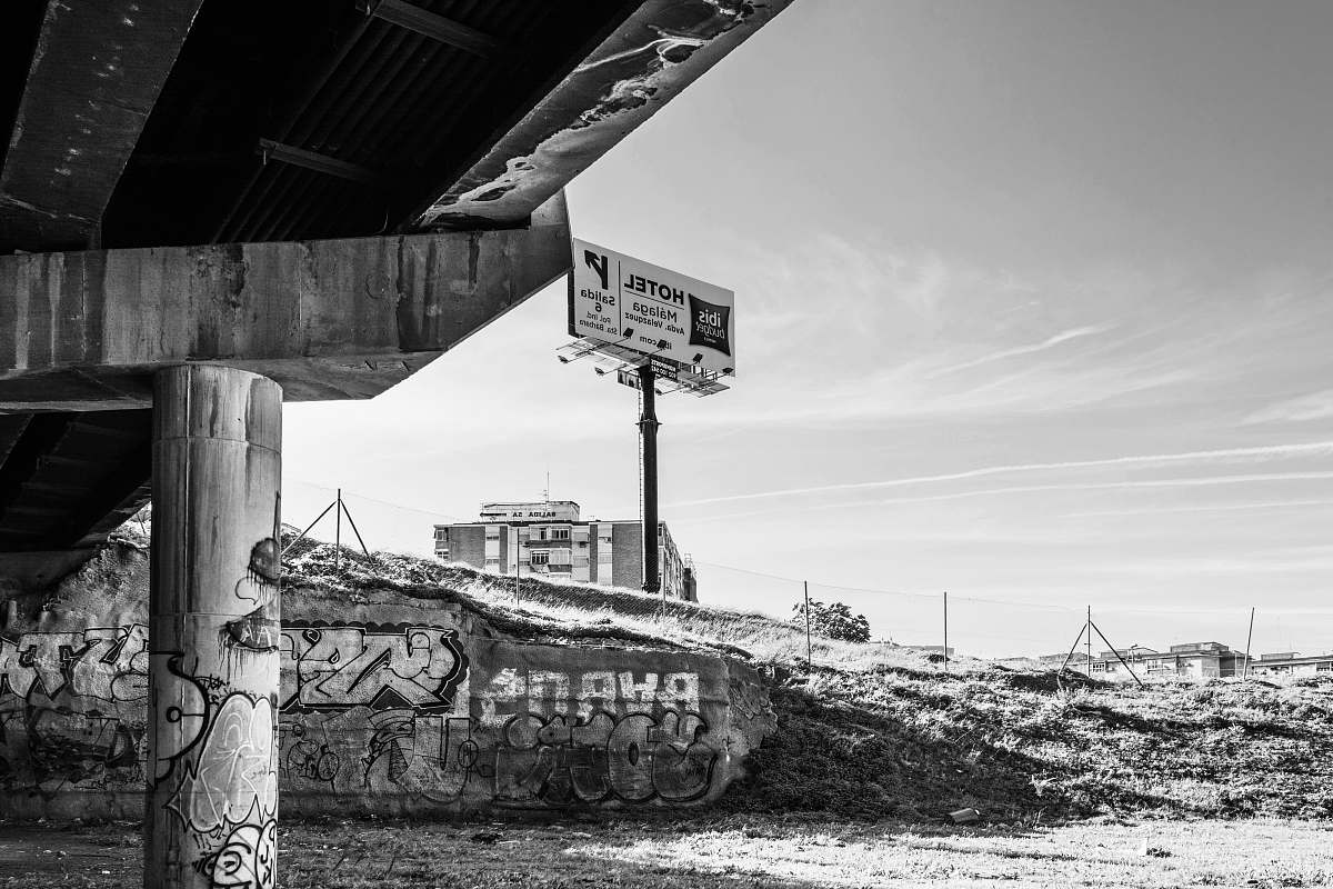 grey greyscale photography of bridge underpass and billboard road