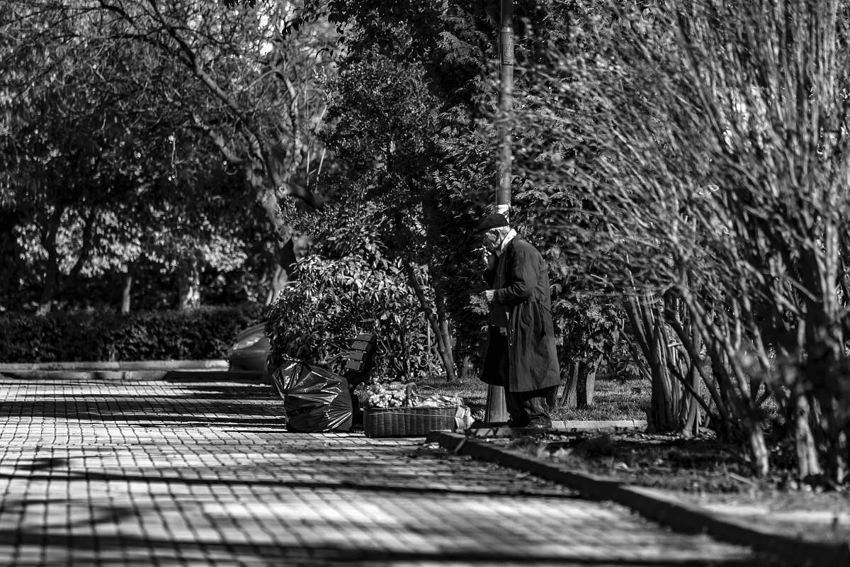 apparel greyscale photography of man standing on curb during daytime clothing