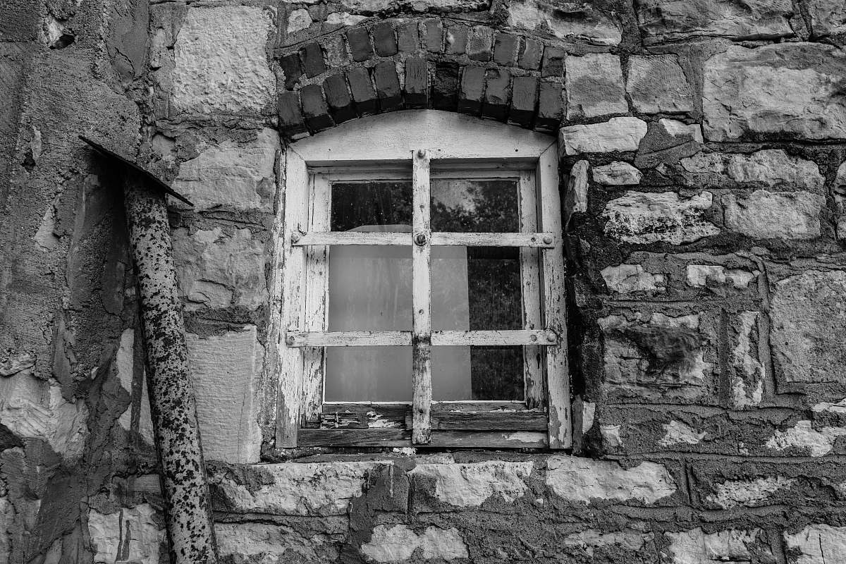 brick greyscale photography of window door