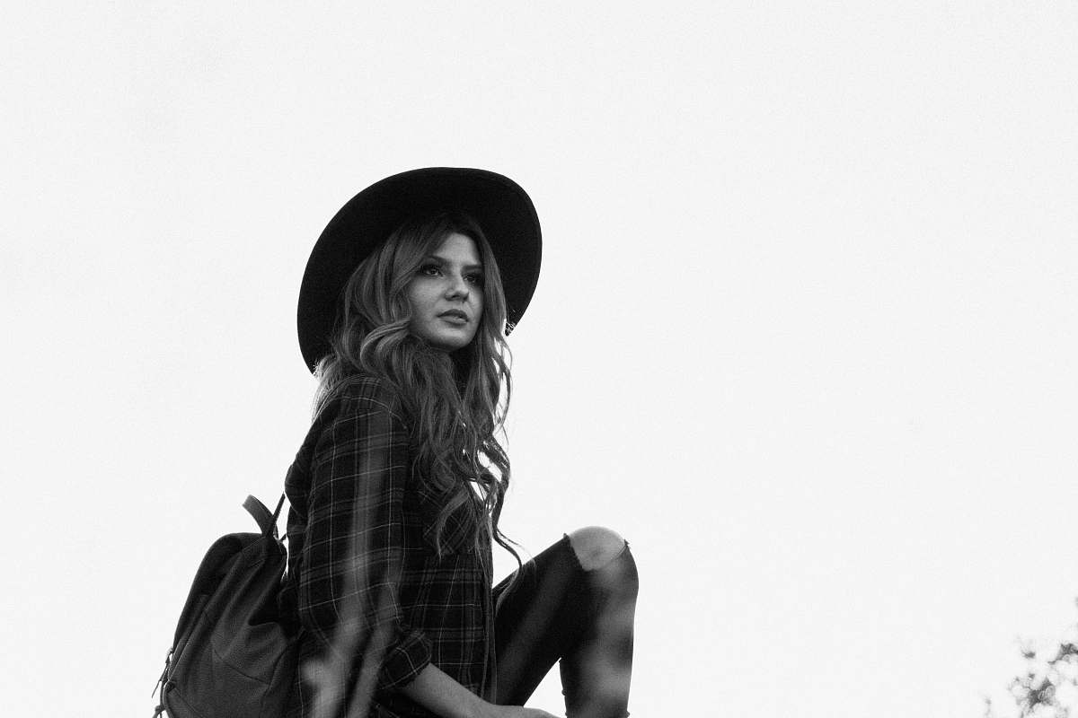 apparel greyscale photography of woman wearing hat clothing