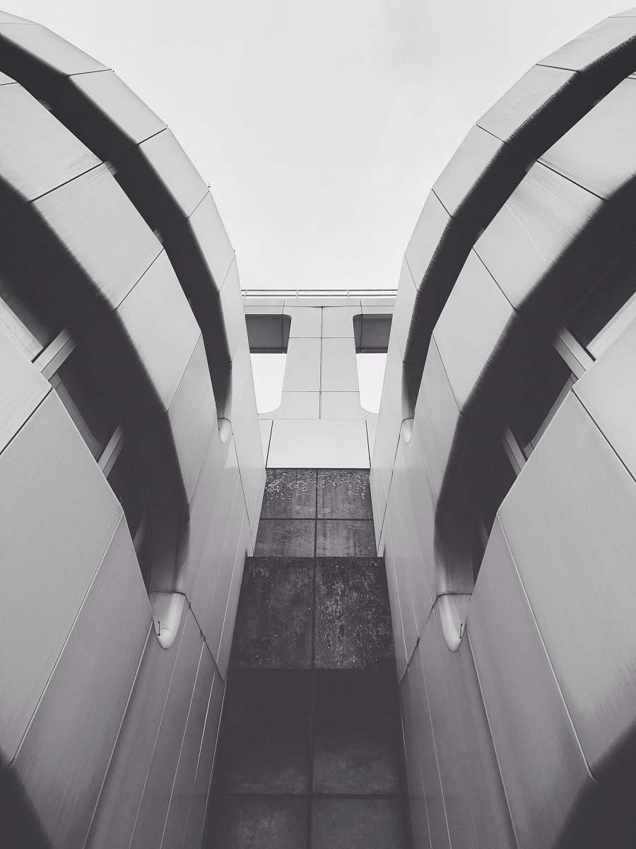 banister low angle and grayscale photography of building during daytime handrail