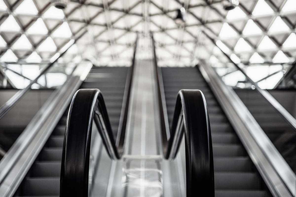 handrail low angle photo of escalator banister