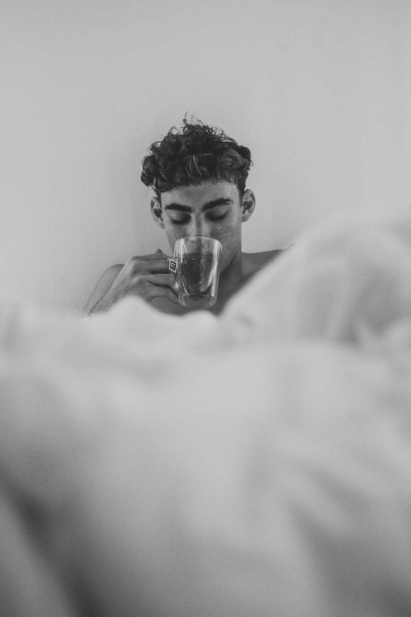 human man holding clear glass cup drinking liquid person