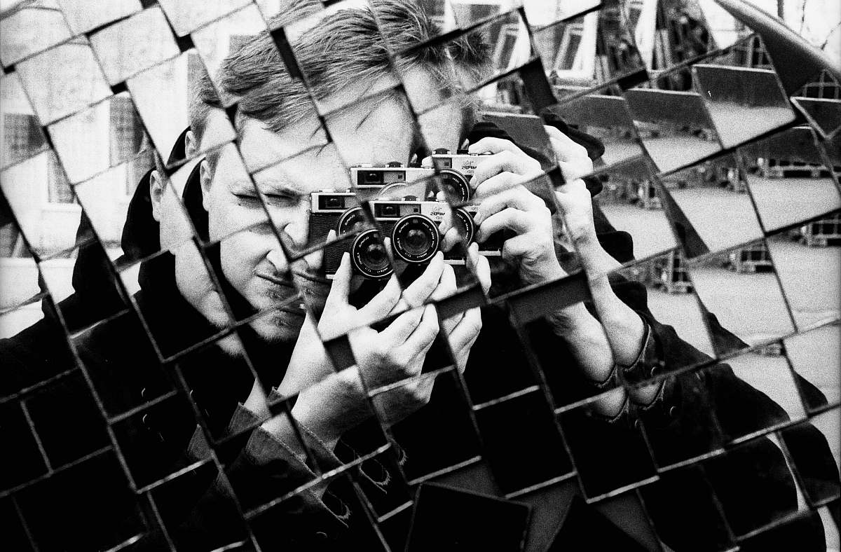 reflection man holding DSLR camera mirror