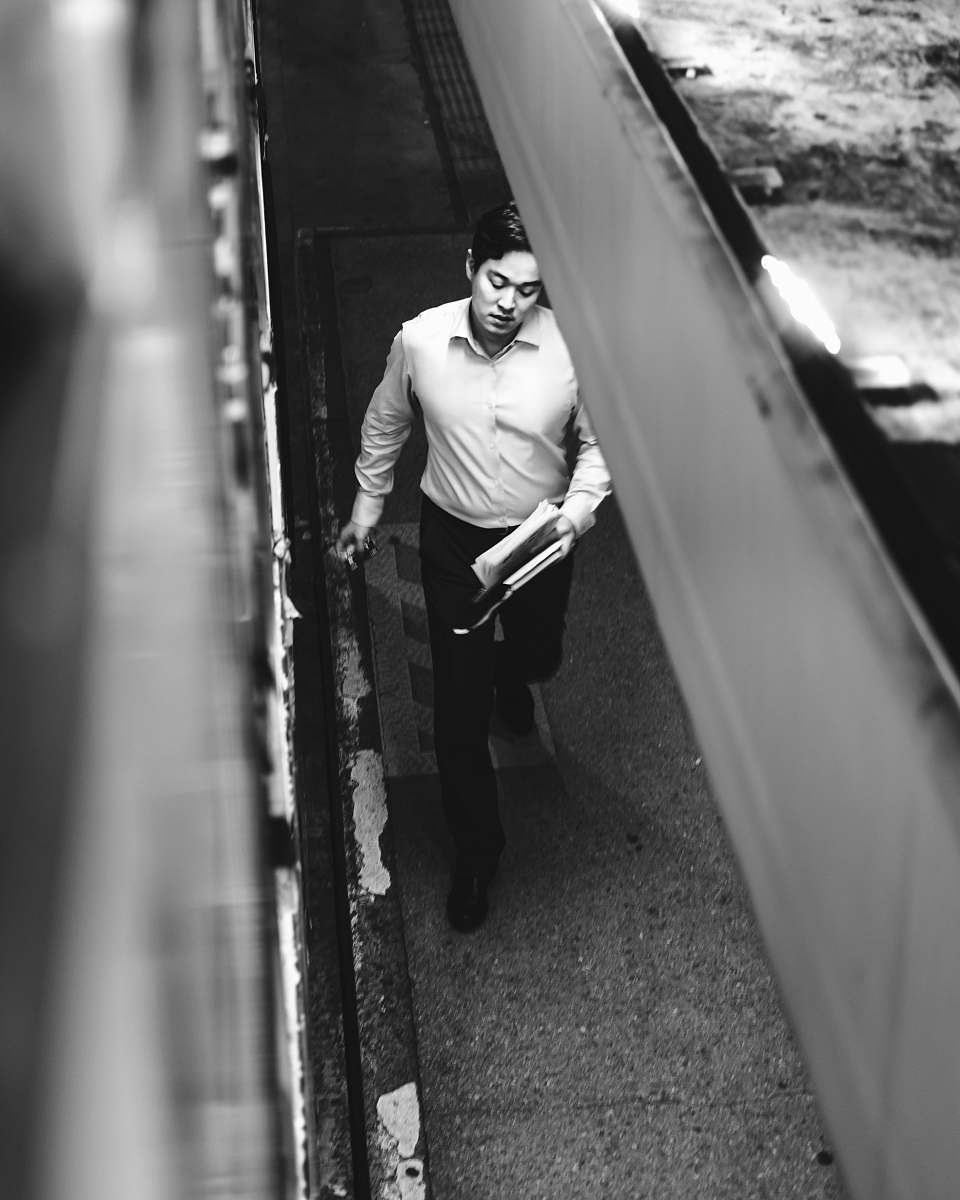 human man in dress shirt and pants walking on sidewalk person
