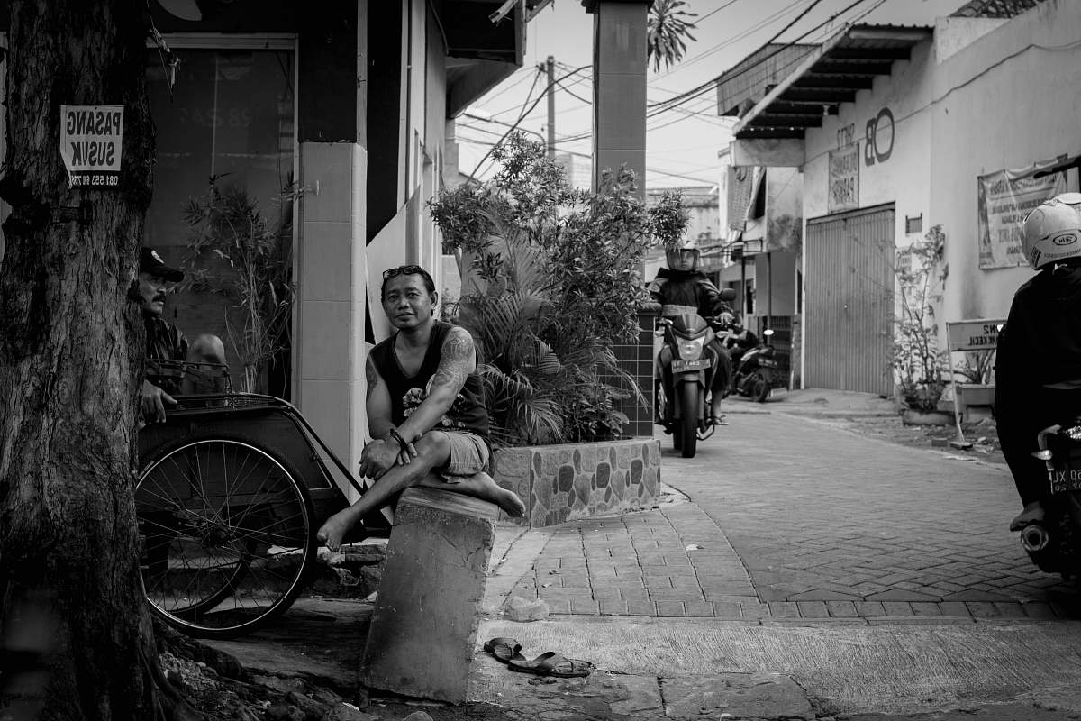 machine man sitting beside bike wheel