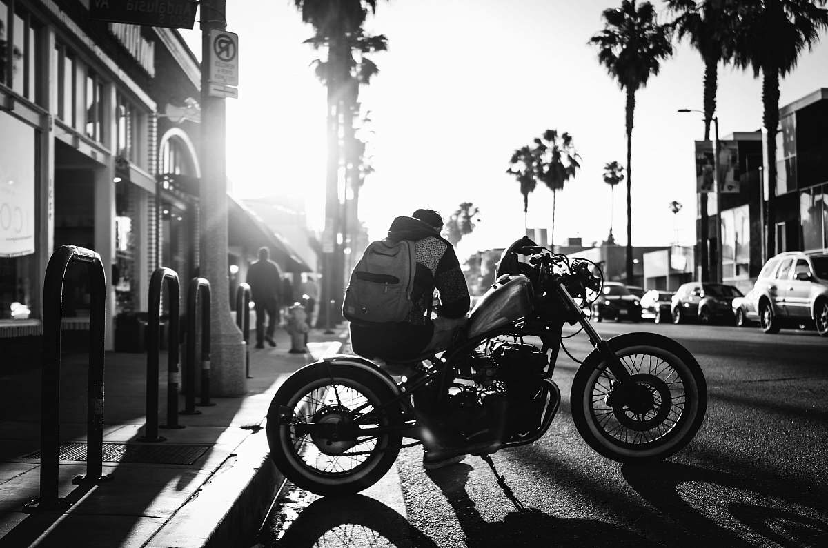 transportation man sitting on cruiser motorcycle on grayscale photograyphy motorcycle