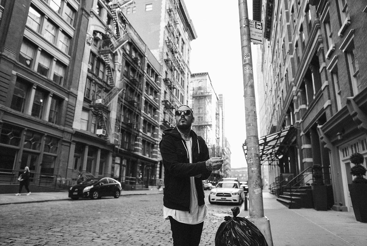 human man standing beside the pole near the street person
