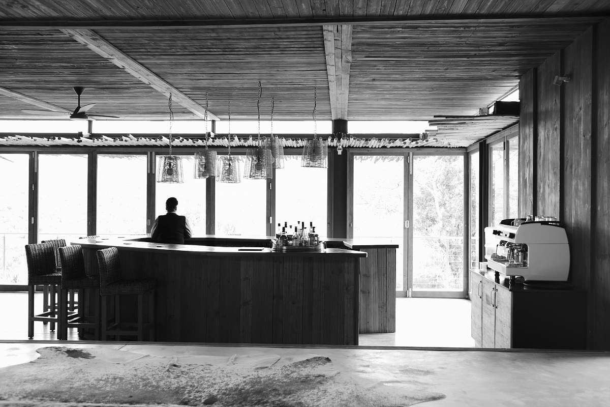 human man standing inside bar counter in grayscale photo person