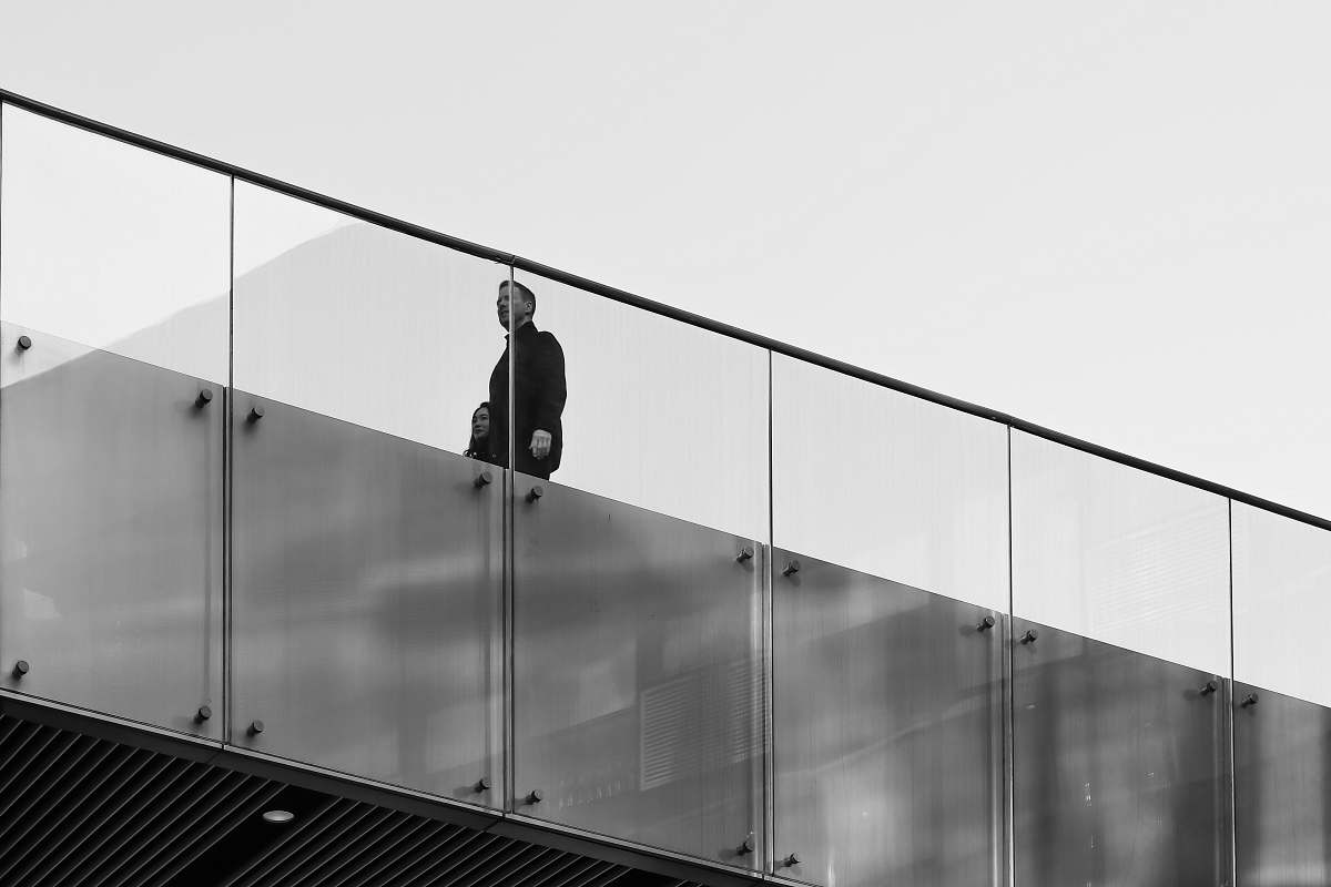 banister man walking near glass railing handrail