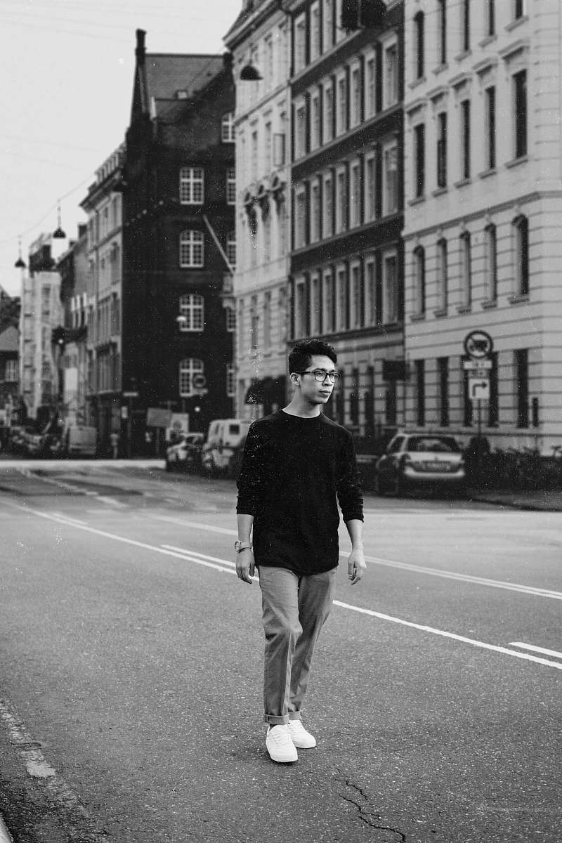 apparel man walking on road by buildings clothing