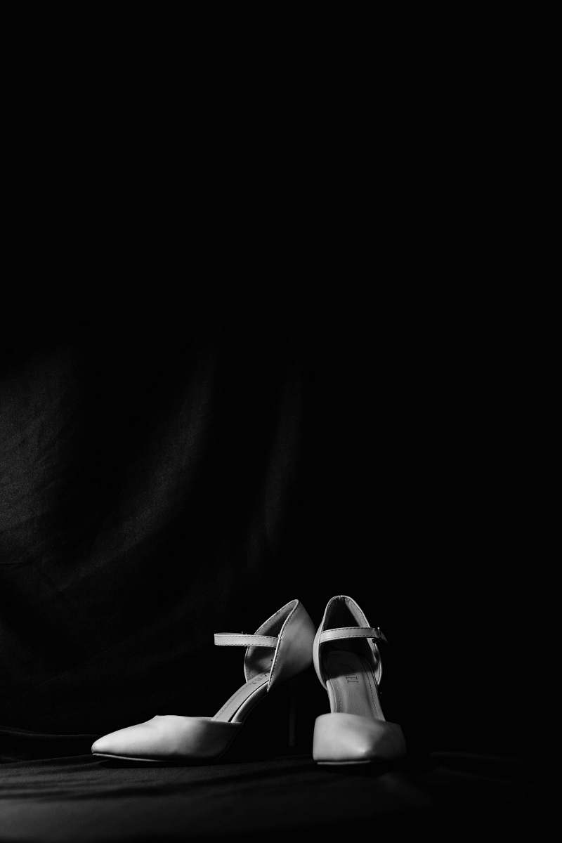 human pair of white leather pointed-toe heels black