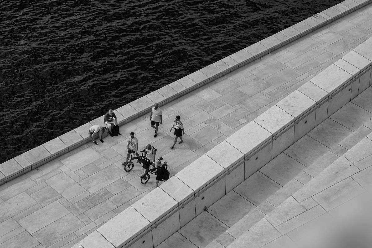 human people walking on pathway near body of water water