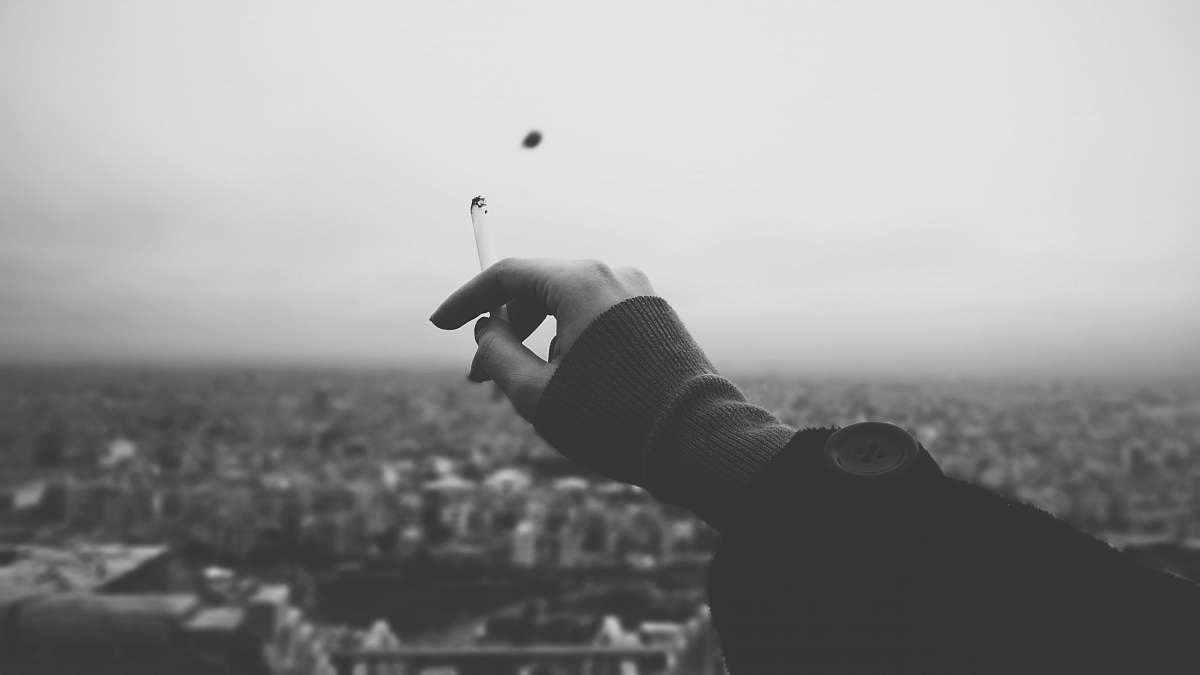 grey person holding cigarette stick hand
