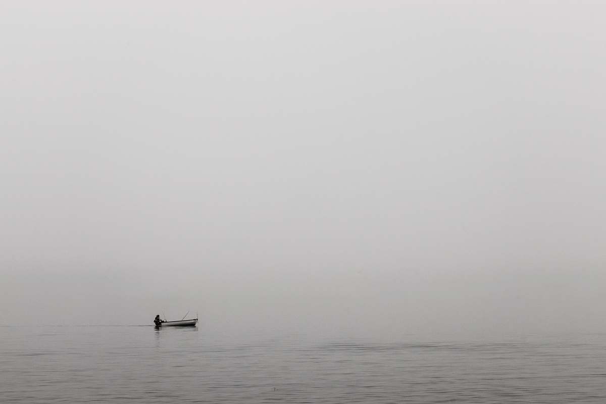 grey person sitting on white boat on ocean water nature