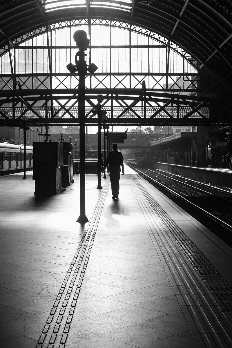 human person walking in station grayscale photography person
