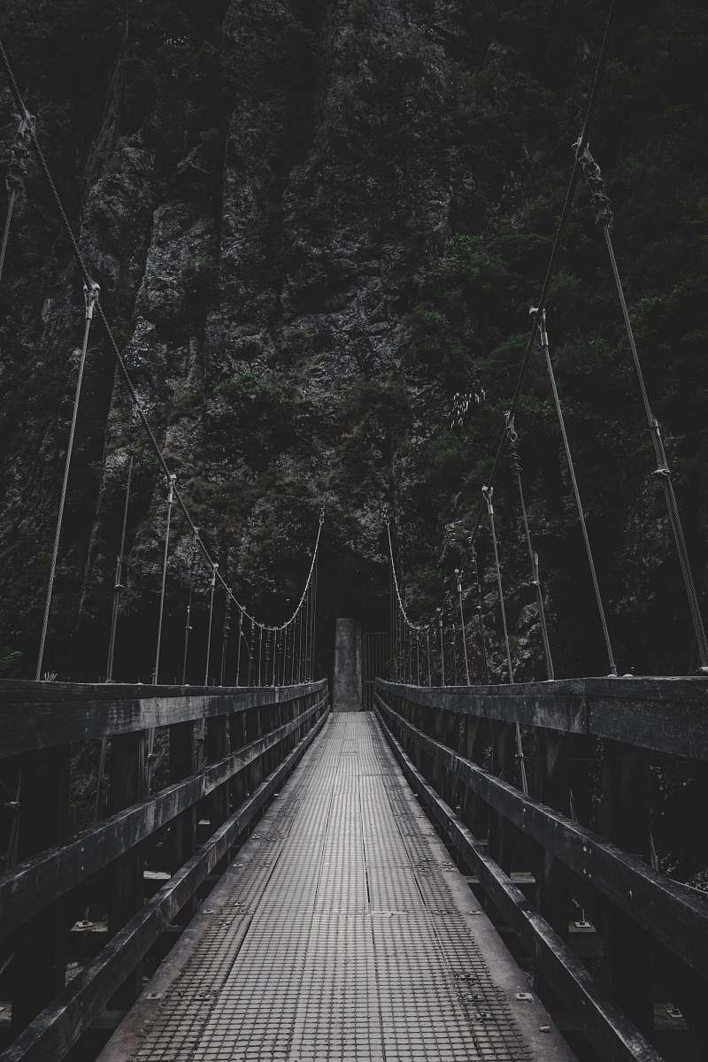grey photo of bridge near mountain bridge
