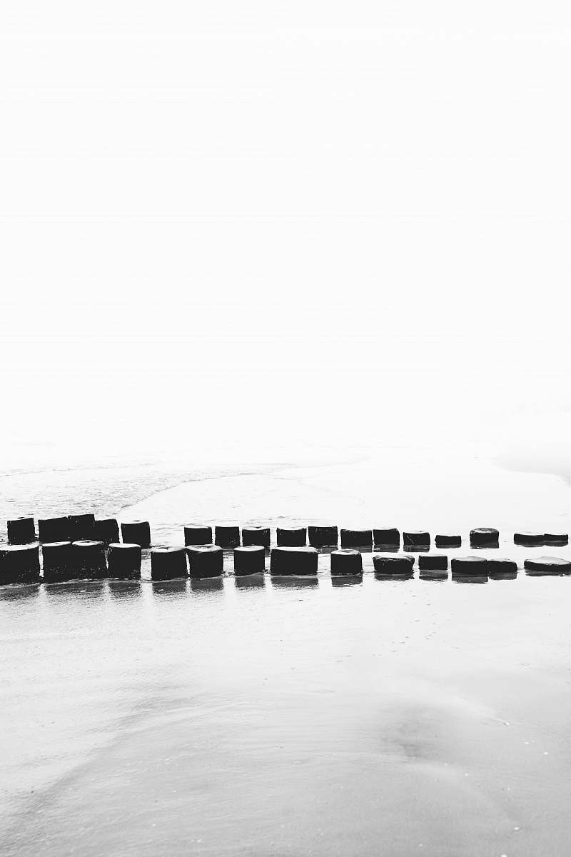 water pile of wooden pillars between snowfield waterfront