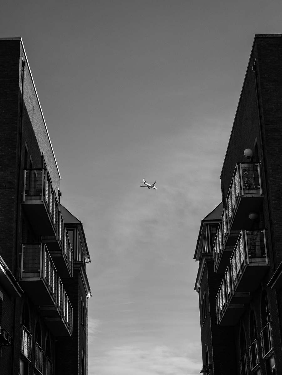 grey plane between building asphalt