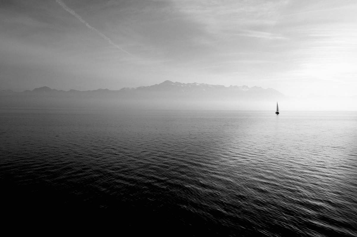 mountains sailboat on calm body of water under white sky at daytime desktop wallpapers