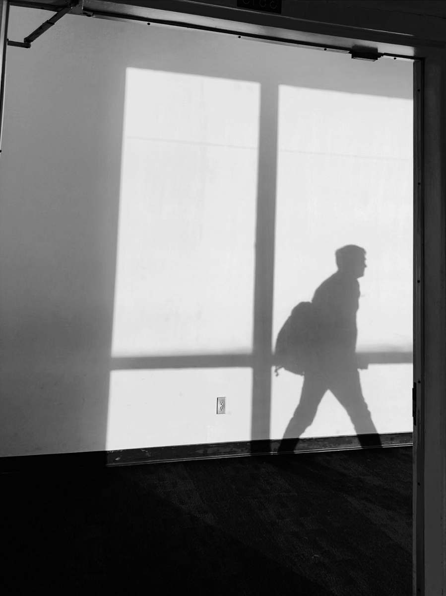 silhouette shadow of man cast on concrete wall shadow