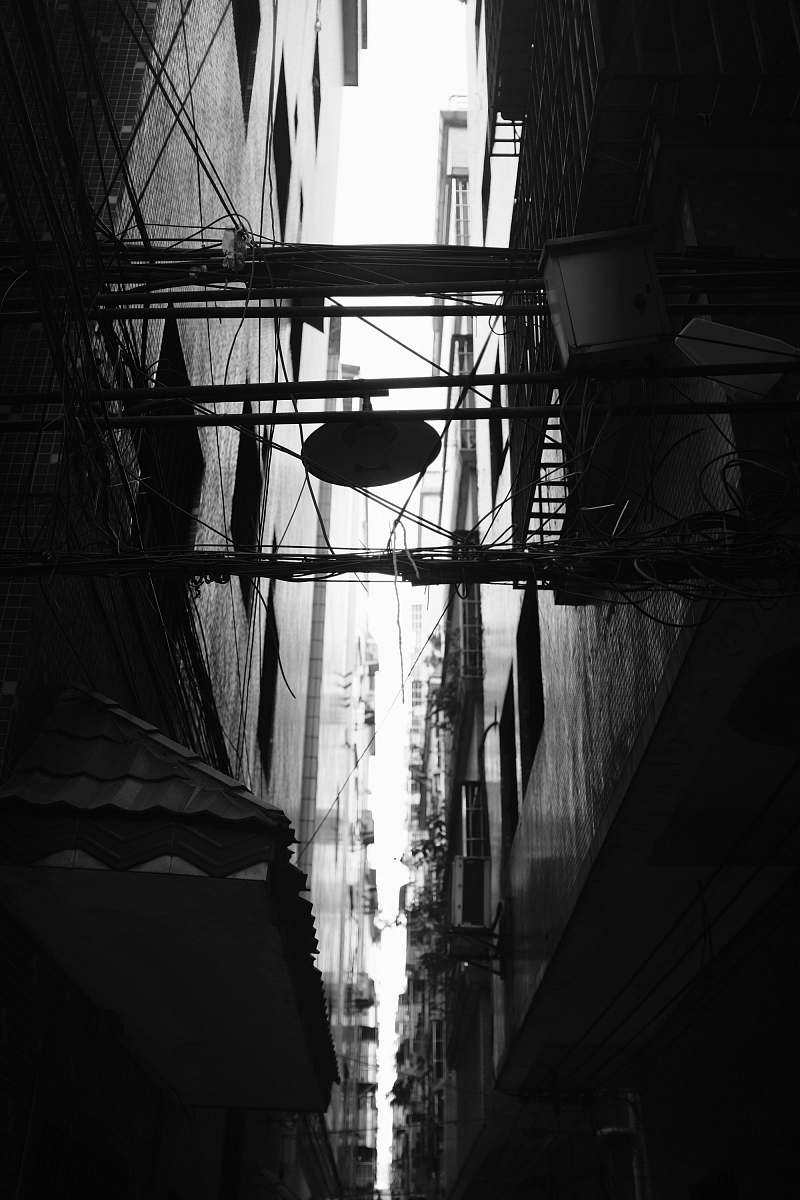 dock silhouette of cables in between concrete buildings at daytime pier