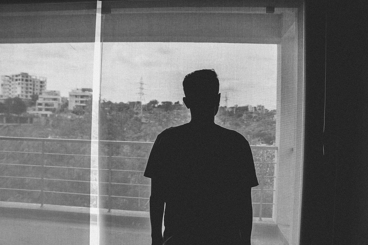human silhouette of man standing inside room grey