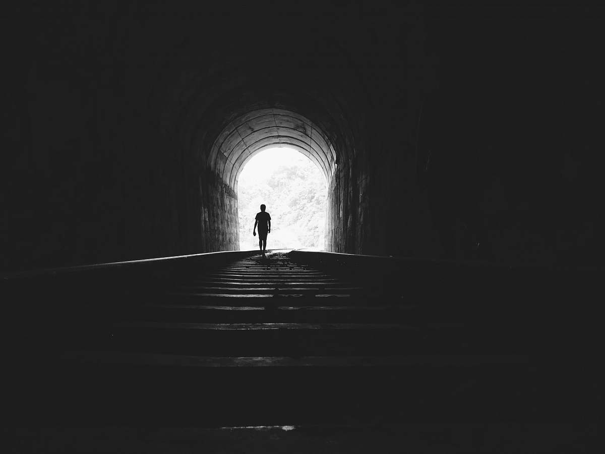 person silhouette of man under tunnel human