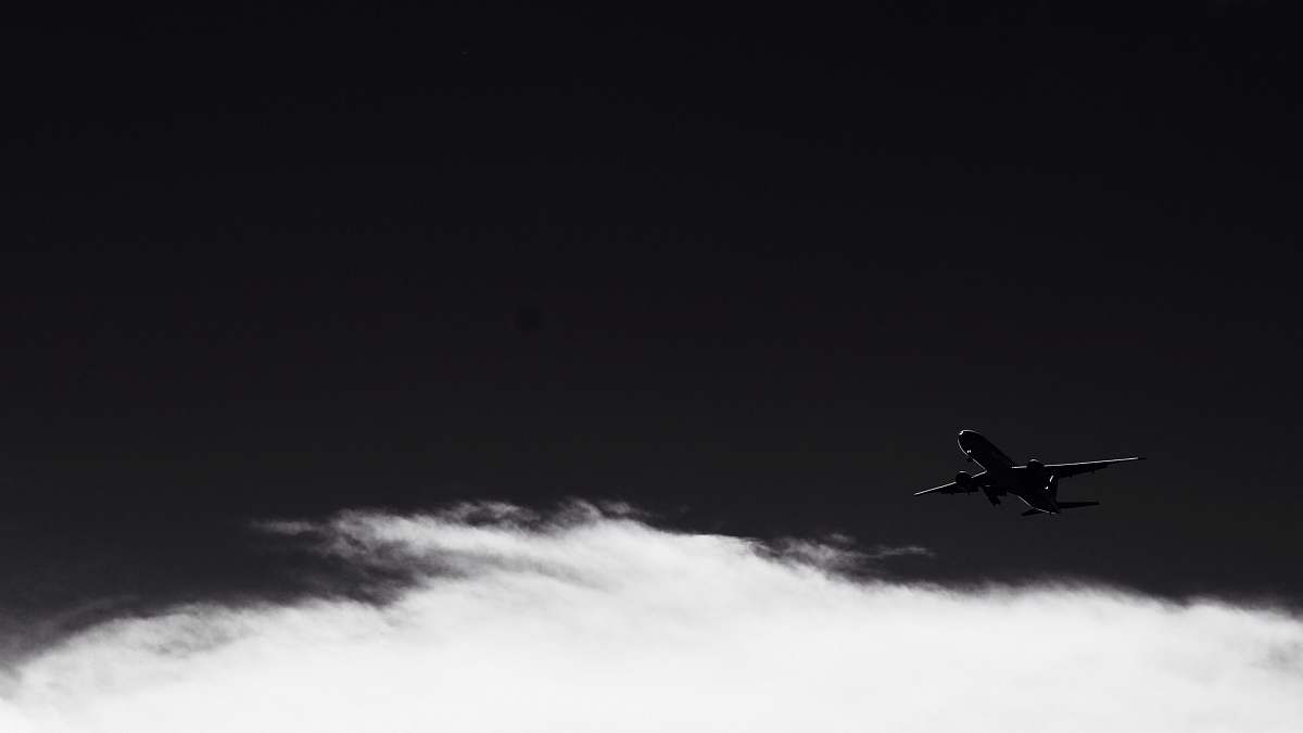 grey silhouette photo of flying plane flying