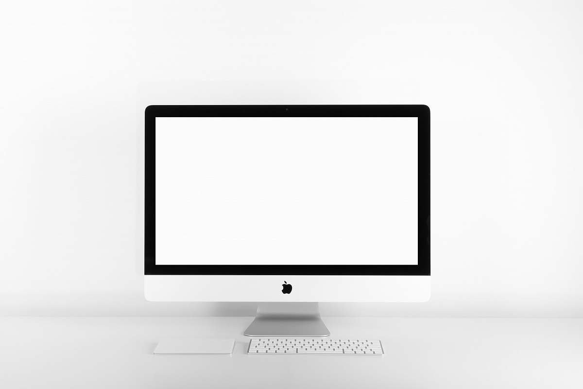 screen silver iMac with Apple Magic Keyboard on white sufrace desk