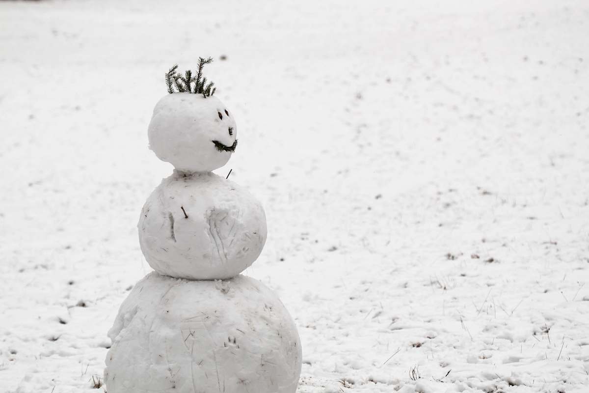 grey snow made snowman on snow covered field during daytime outdoors