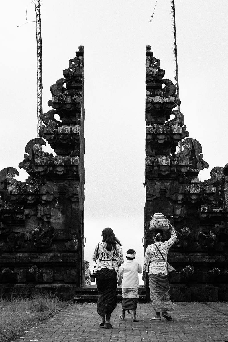 human three person walking through building grayscale photography person