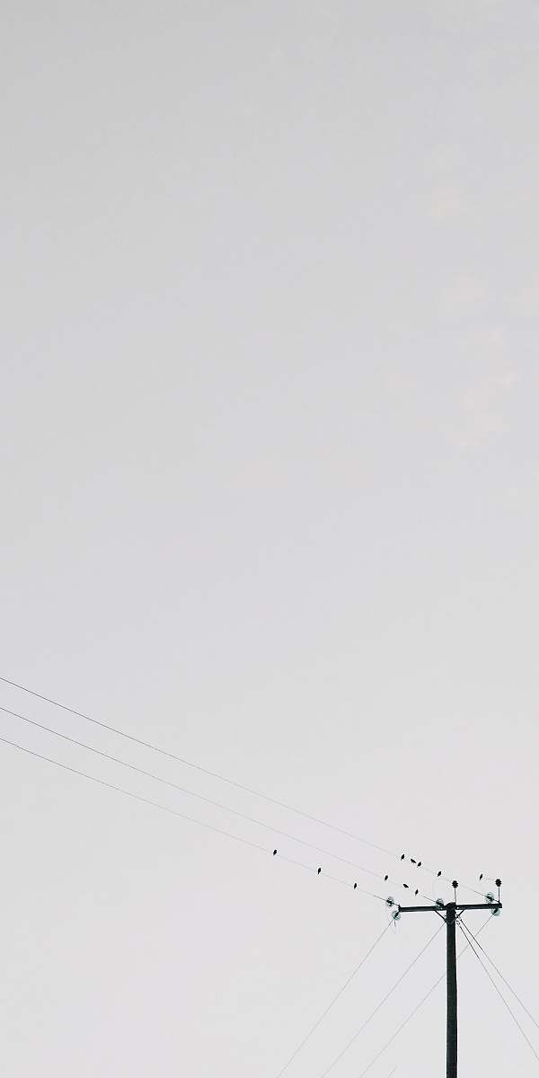grey transmission post under white clouds lamppost