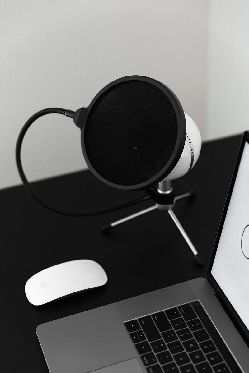 speaker turned-on MacBook Pro beside Magic Mouse electronics