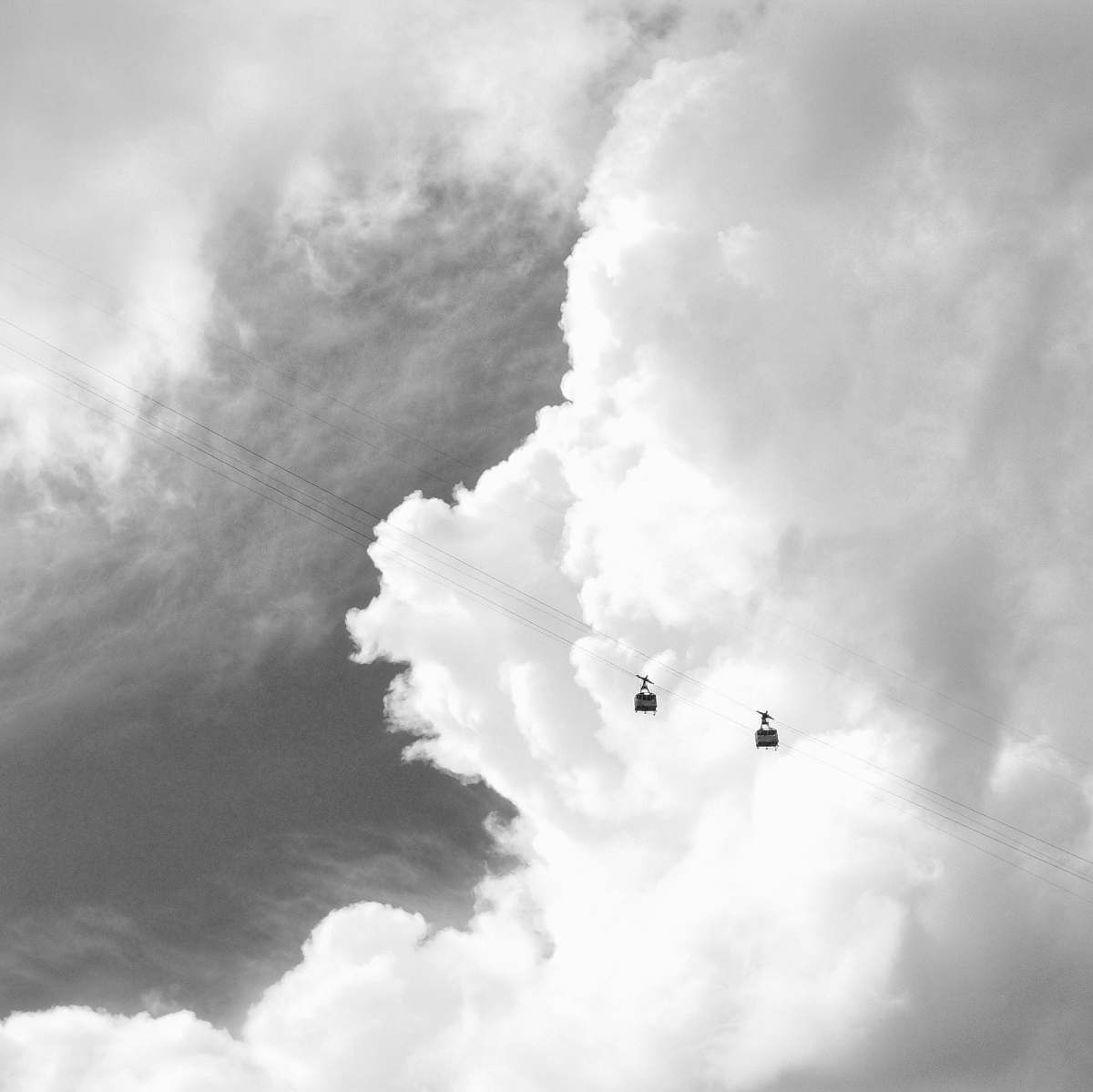 cloud two black cable cars under grey sky sky