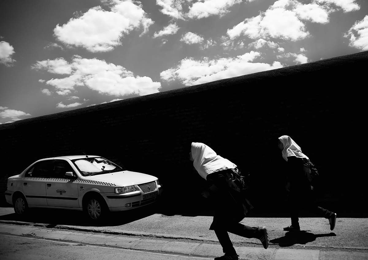 car two persons running on street near car automobile