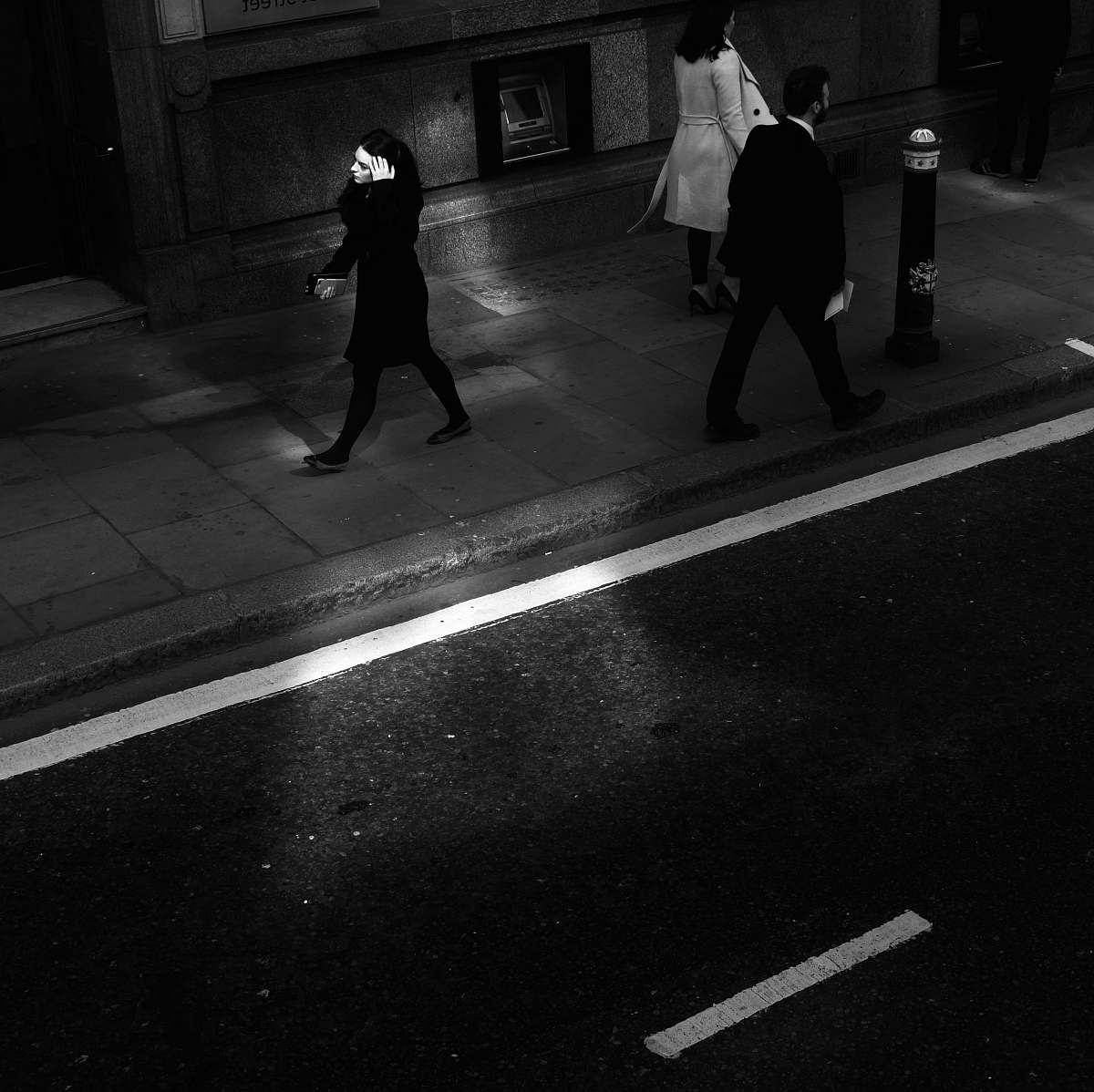 human two women and man walking along side of road pedestrian