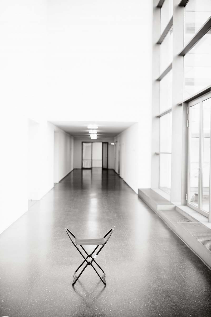 flooring vacant white chair in between hallway of building floor