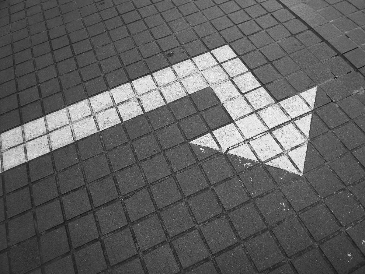 grey white arrow on bricked pavement flooring