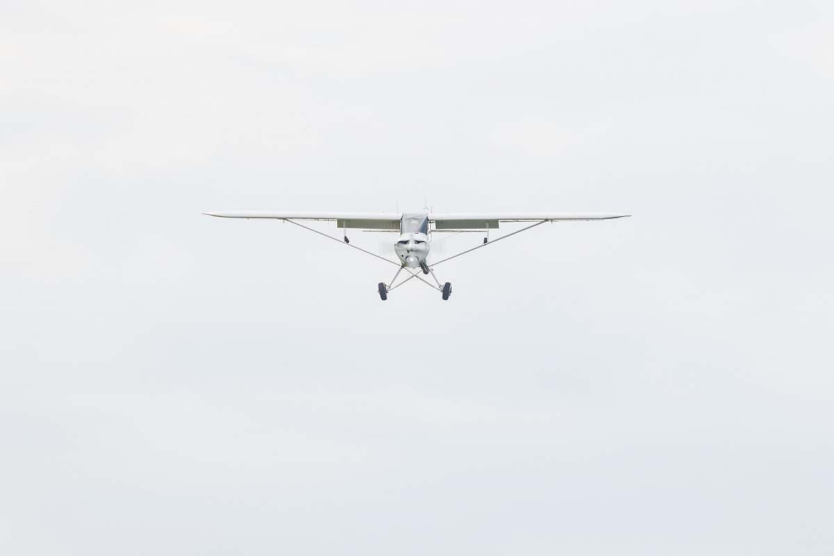 aircraft white monoplane flying during daytime airplane
