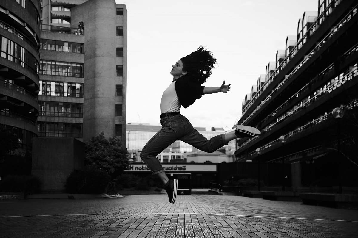person woman jumps on grayscale photography human