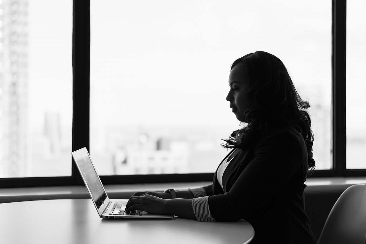 human woman sitting and using laptop person