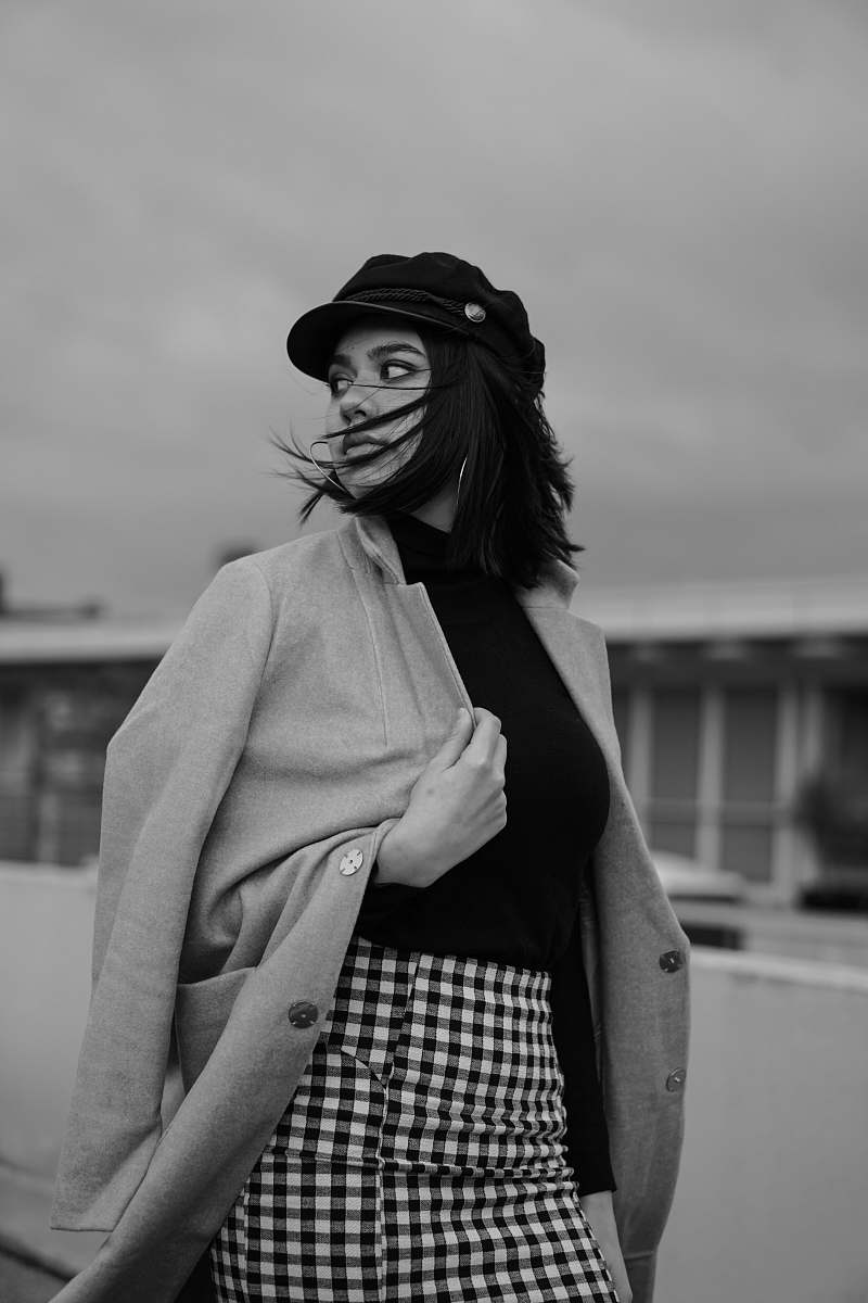 clothing woman walking on street in grayscale photography apparel