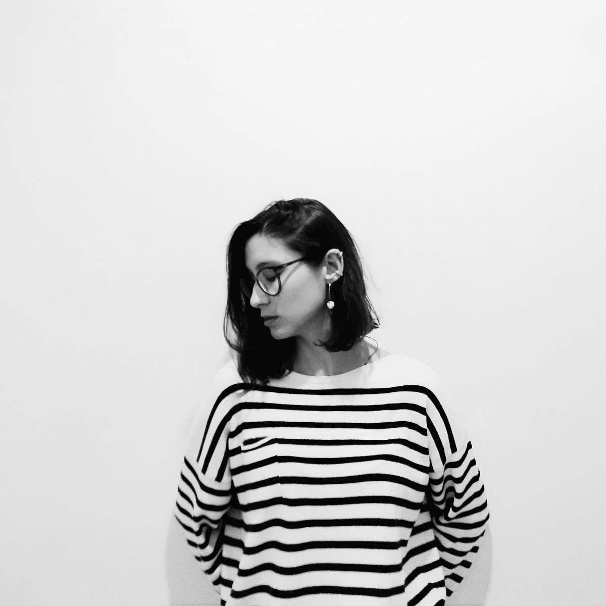sleeve woman wearing striped shirt leaning on wall apparel