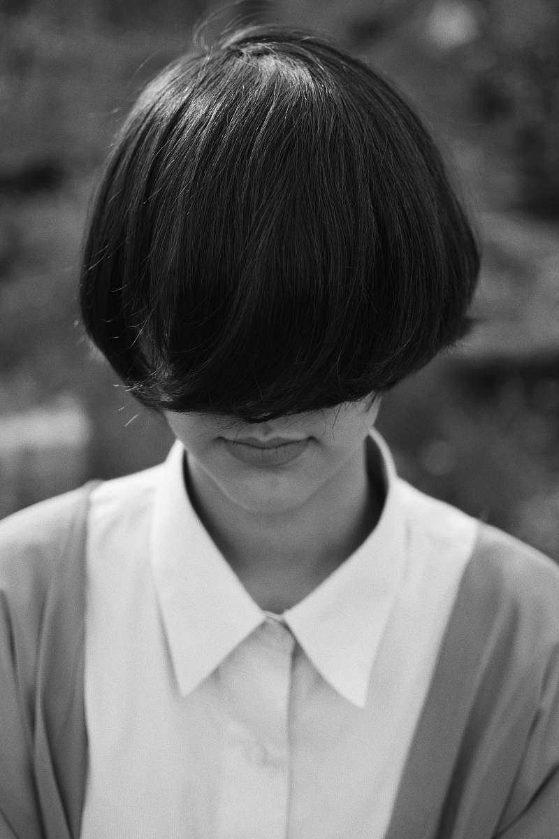 person woman with cropped hair covering her face human