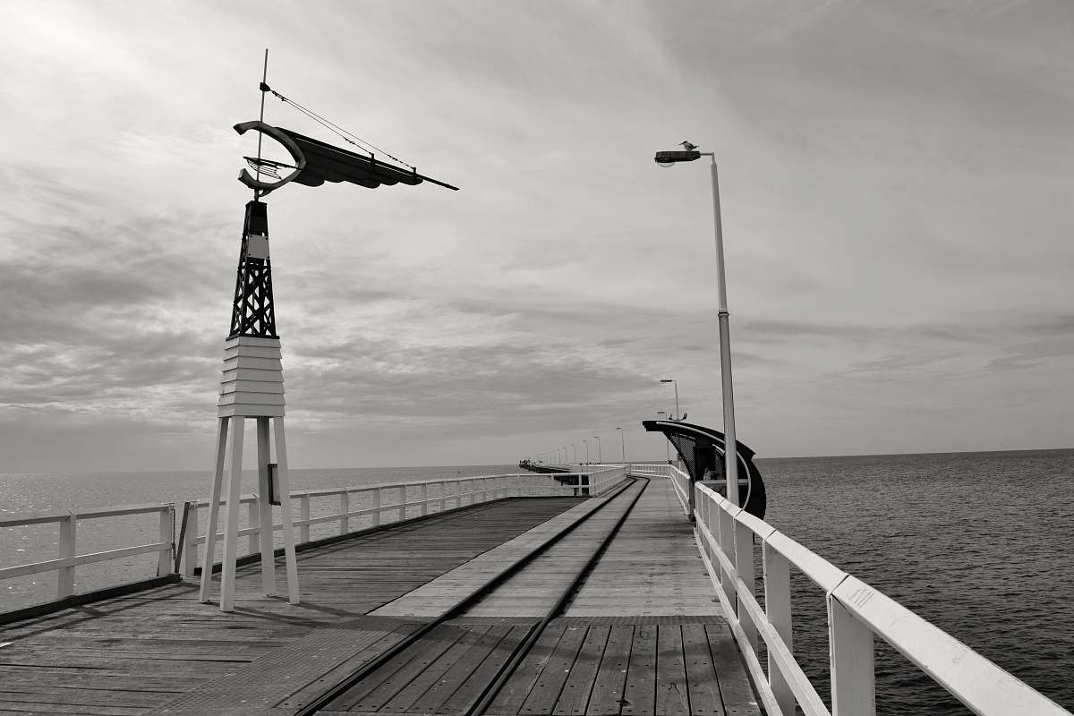 dock wooden wind vane on bridge near the body of water pier