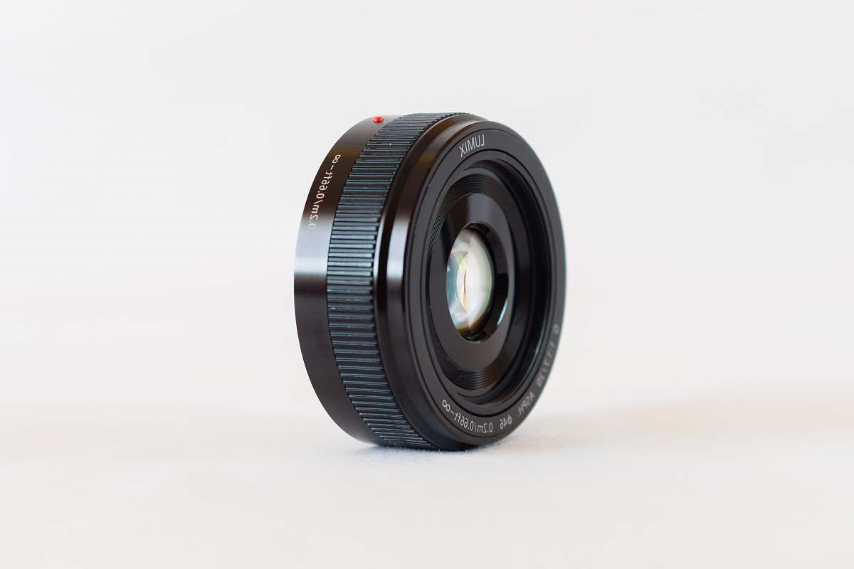 lumix black camera lens on white surface lense