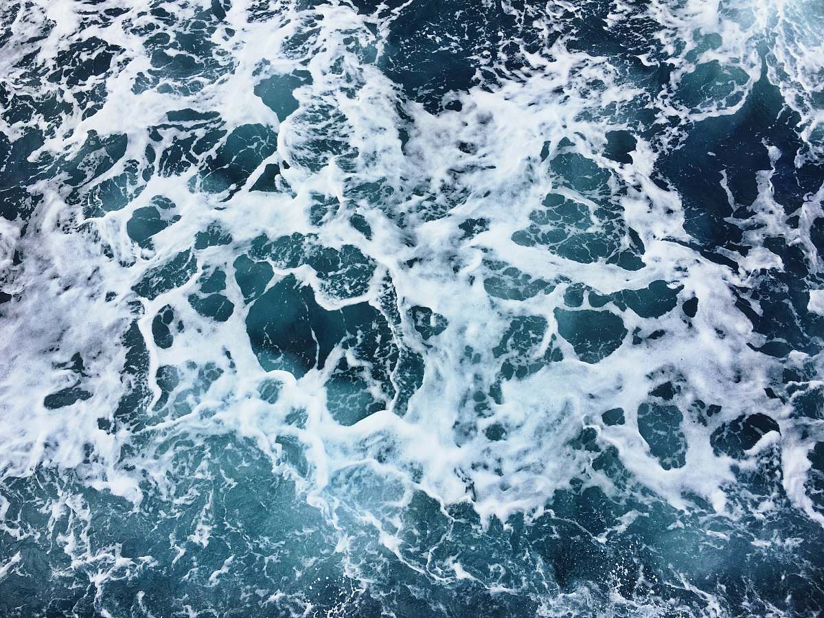 water aerial photography of sea foam during daytime ocean