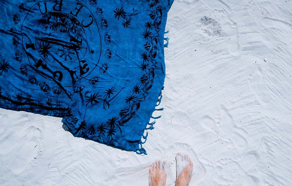 summer blue and black floral scarf on white sand feet